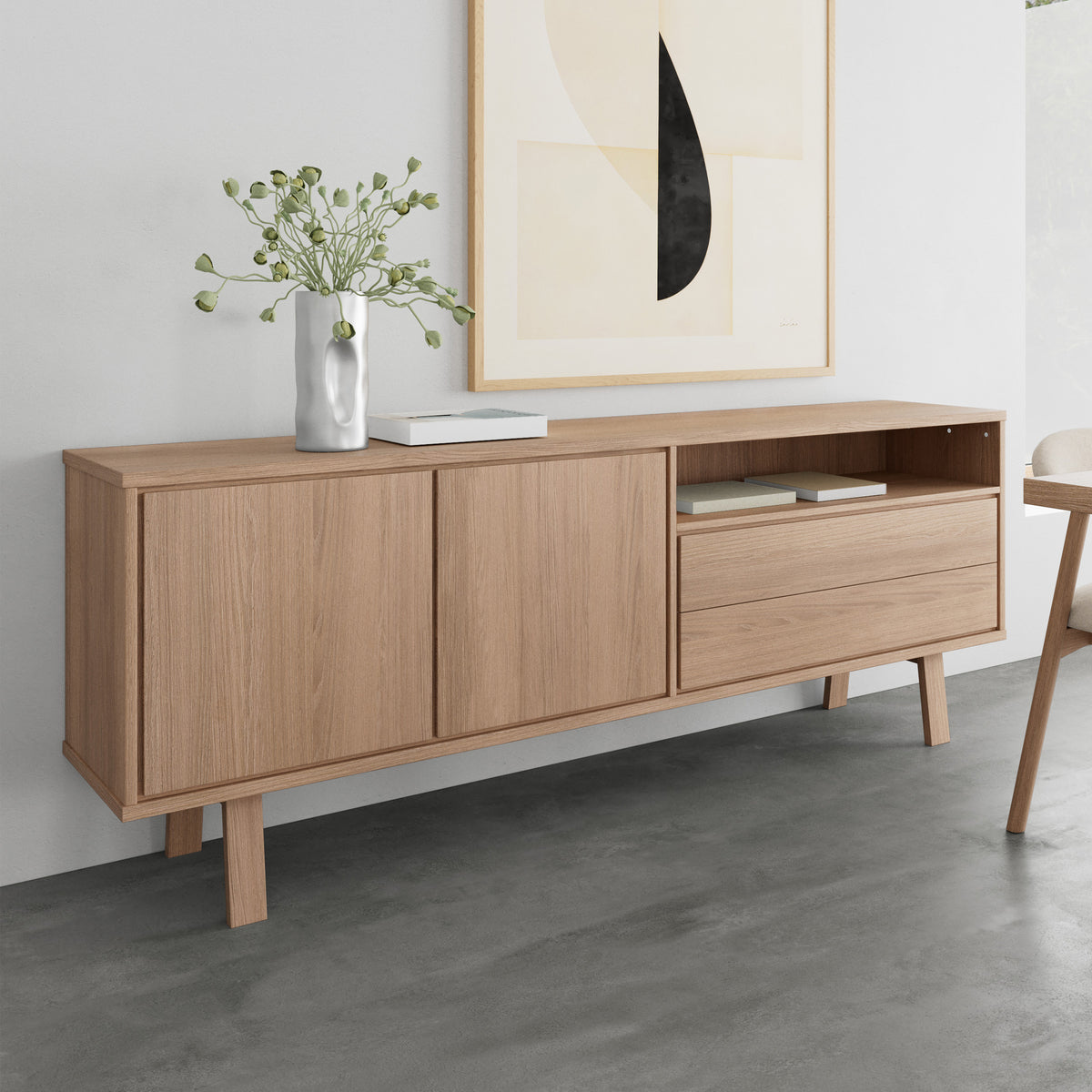 Kommode „Lurisse“ 200 x 75, gebleichte Eiche, vor einer grauen Wand unterhalb der Grafik, mit Vase und Büchern – Kommode für das Wohnzimmer