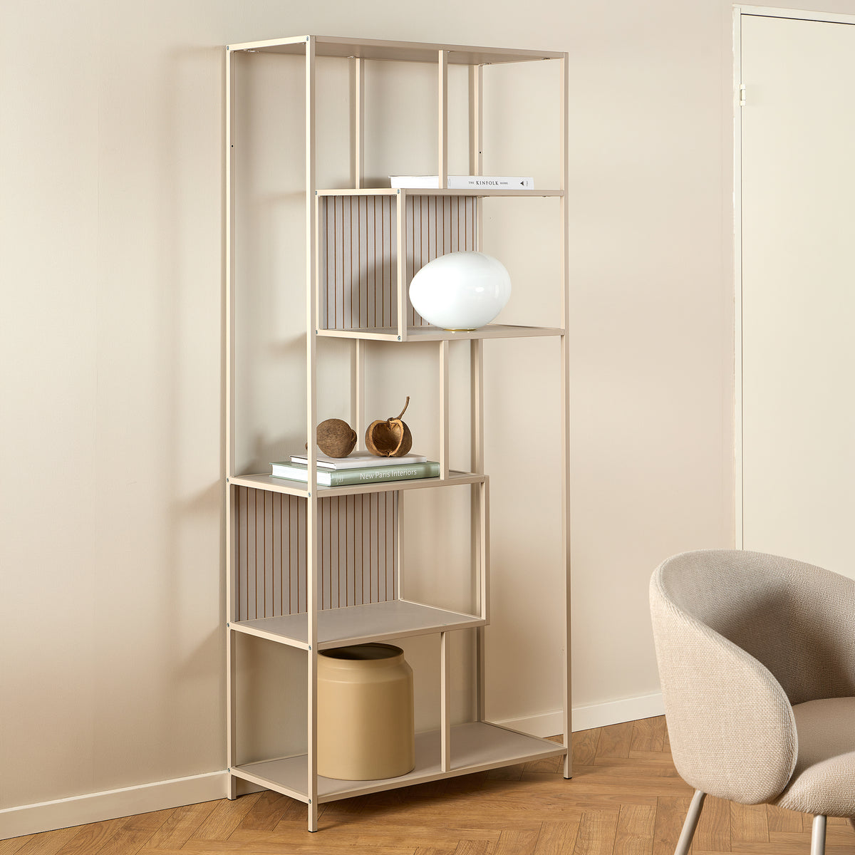 Regal „Skeleto“ 77 x 185, graues Melamin, in einem hellen Raum neben einem Sessel, mit einer kugelförmigen Lampe – ein Regal für das Wohnzimmer