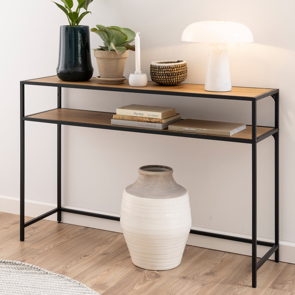 Konsole „Skeleto“ 120 x 79, „Wilde Eiche“, vor einer hellen Wand mit einer Lampe, Pflanzen und Büchern im Regal – eine Konsole für den Flur