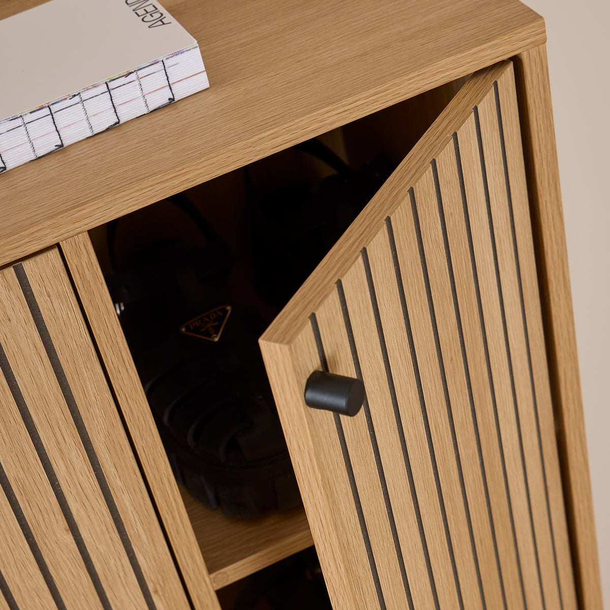 Schuhschrank Bambouz 99x141 – Detailansicht der angelehnten Tür mit schwarzem Knauf und Schuhen auf dem Regal
