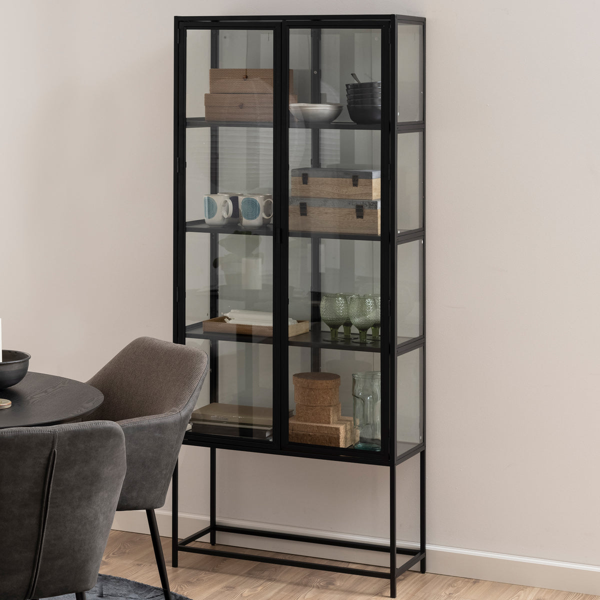 Vitrine „Skeleto“ 77 x 186, schwarz, Melamin, im Esszimmer neben einem runden Tisch – eine Vitrine im Industrial-Stil für Geschirr