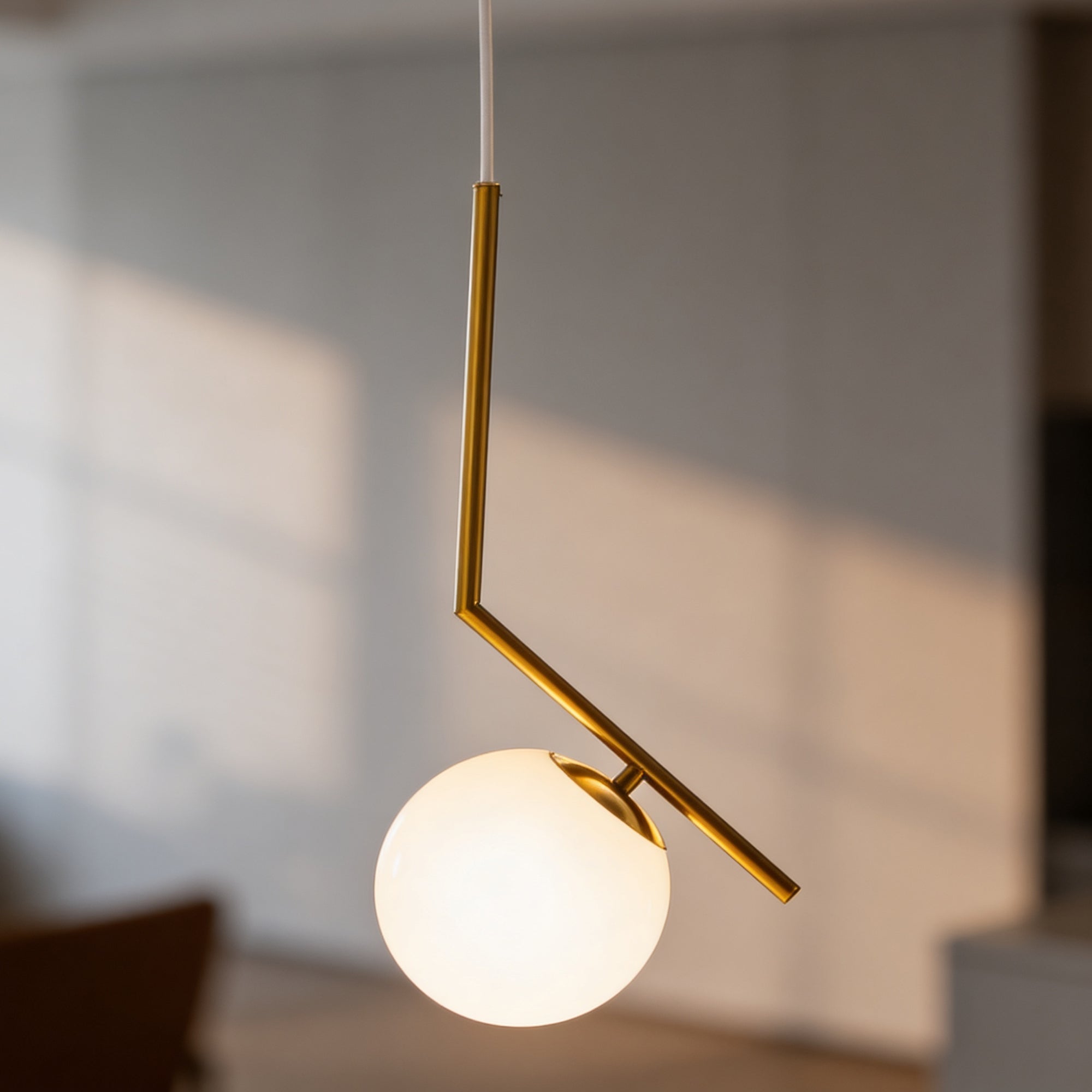 Lampa wisząca z kulistym kloszem na ramieniu w stylu nowoczesnym – złota konstrukcja, biały klosz | Orbitella