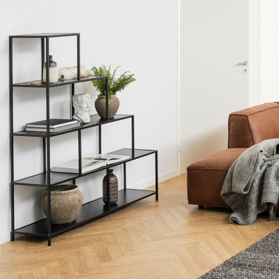 Regal „Skeleto“ 135 x 150, schwarzes Melamin, im Wohnzimmer neben einem braunen Sofa, mit einer Pflanze, einer Büste und Büchern