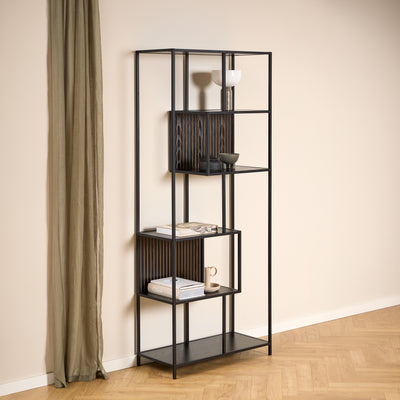Regal „Skeleto“ 77 x 185, schwarzes Melamin, vor einer hellen Wand neben einem Leinenvorhang, mit Keramik und Büchern auf den Regalböden