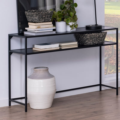 Skeleto-Konsole 120 x 79, schwarz, Melamin, an der Wand stehend, mit Körben, Büchern und einer Pflanze, darunter eine Vase
