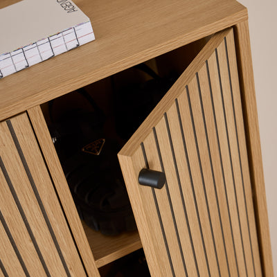 Schuhschrank Bambouz 99x141 – Detailansicht der angelehnten Tür mit schwarzem Knauf und Schuhen auf dem Regal